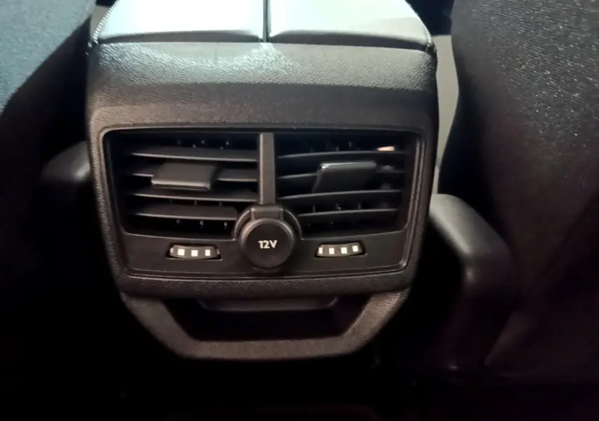 Vue rapprochée des aérateurs arrière noirs et prise 12V du Peugeot 3008 BlueHDi 130 S&S Active Pack 2022.