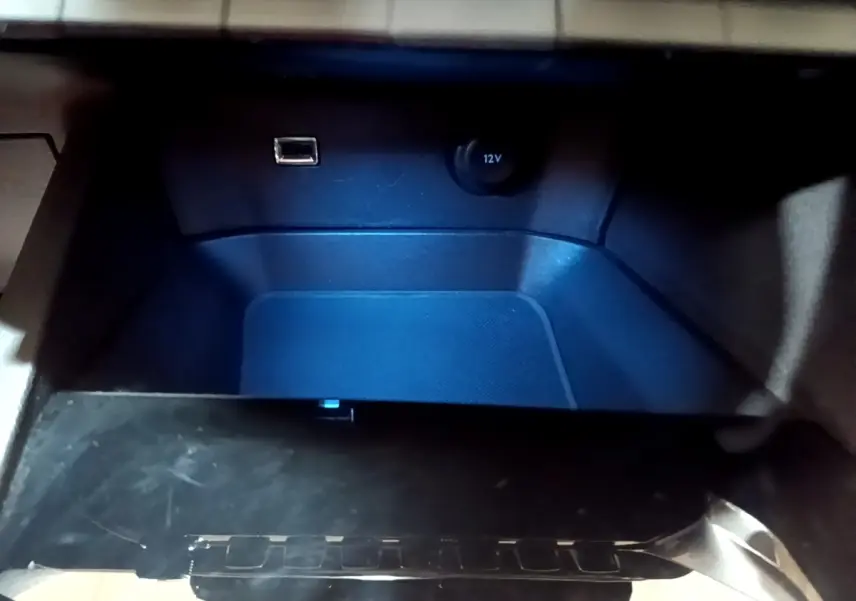 Gros plan de la prise USB et prise 12V dans le rangement intérieur du Peugeot 3008 noir, version 2022.
