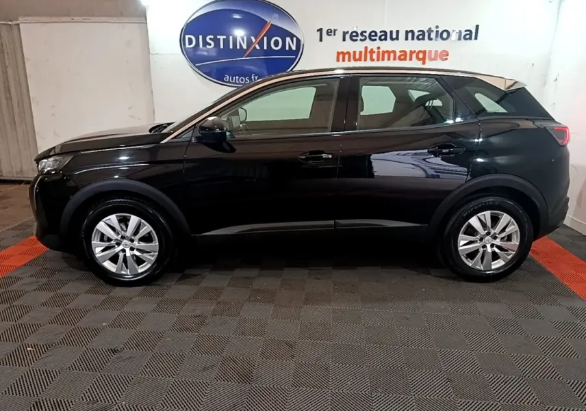 Profil côté gauche du Peugeot 3008 noir 2022 garé en intérieur avec jantes alliage et surface brillante.