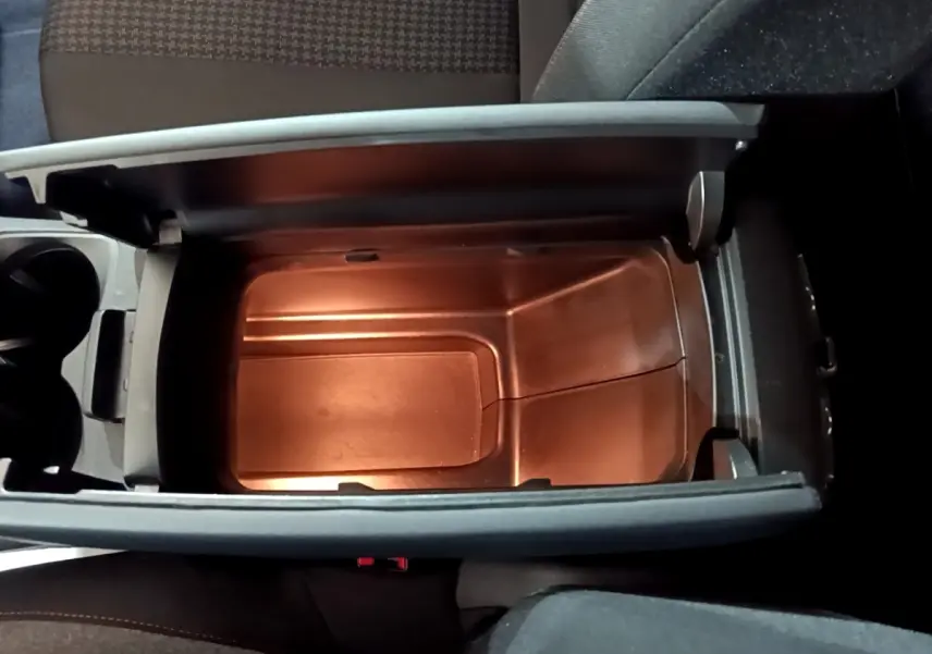 Vue plongeante sur le rangement central ouvert du Peugeot 3008 noir, mettant en valeur l'intérieur spacieux et éclairé.