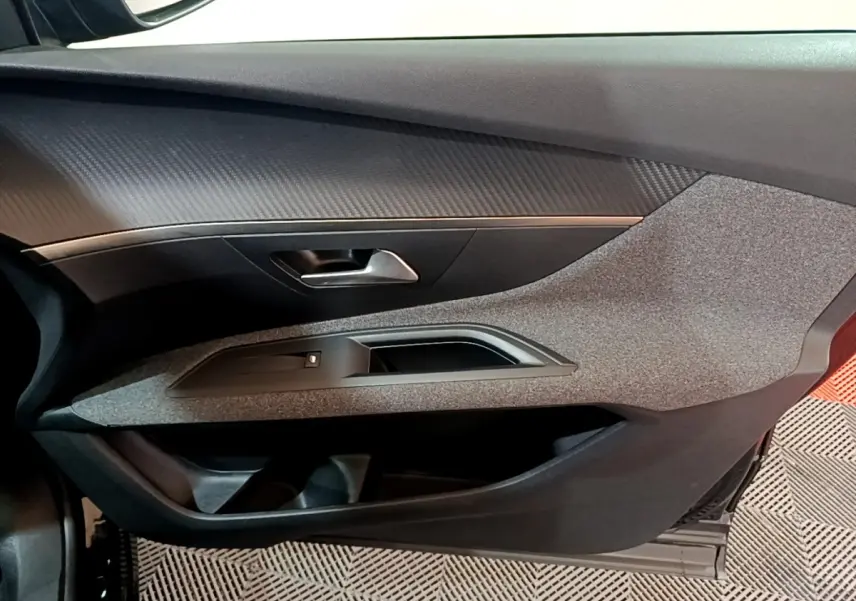 Vue intérieure côté gauche de la porte avant noire du Peugeot 3008 avec habillage texturé et poignée métallique.