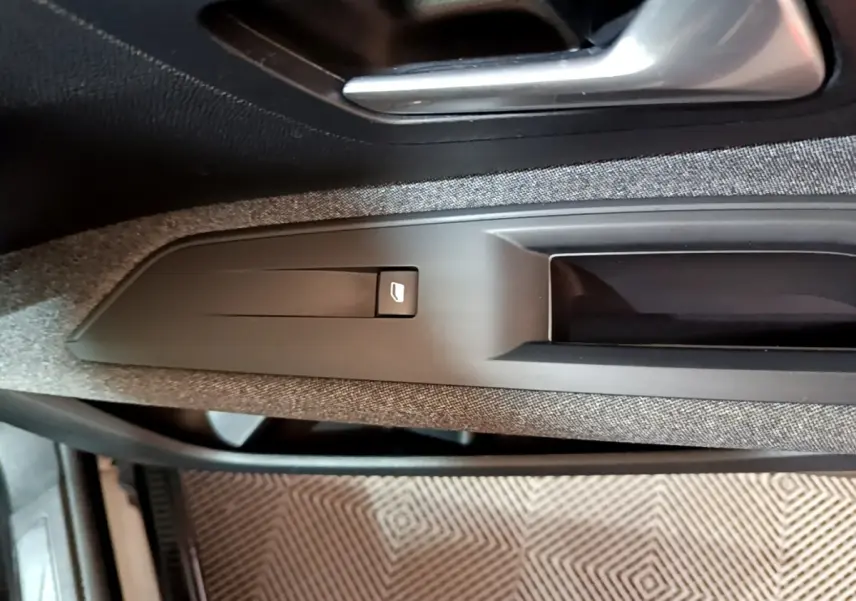 Détail de la commande de lève-vitre côté gauche sur la porte intérieure tissu gris du Peugeot 3008 noir 2022.
