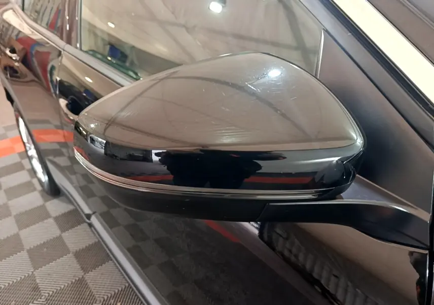 Rétroviseur côté gauche noir brillant du Peugeot 3008 2022, avec carrosserie noire et reflets intérieurs visibles.