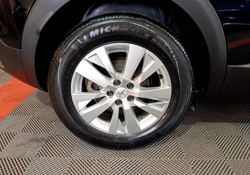 Gros plan sur la roue avant droite d’un Peugeot 3008 noir avec jante alliage et pneu Michelin.