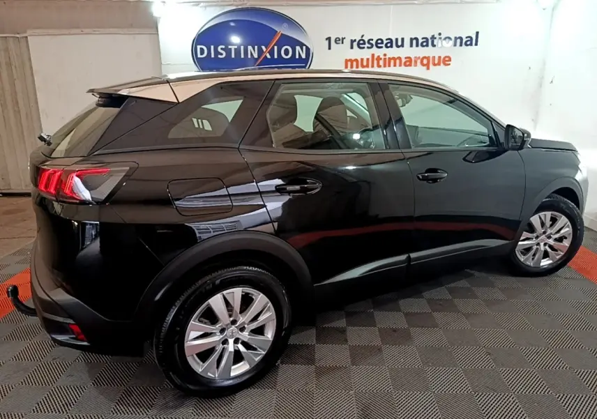 Vue latérale droite du Peugeot 3008 noir 2022 avec feux arrière allumés dans un showroom intérieur.