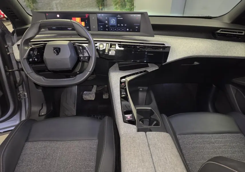 Intérieur avant du Peugeot 3008 gris, avec tableau de bord tissu chiné, volant compact et double écran HD panoramique.