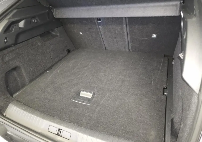 Coffre spacieux du Peugeot 3008 gris, vue intérieure arrière avec banquette rabattue et revêtement noir.