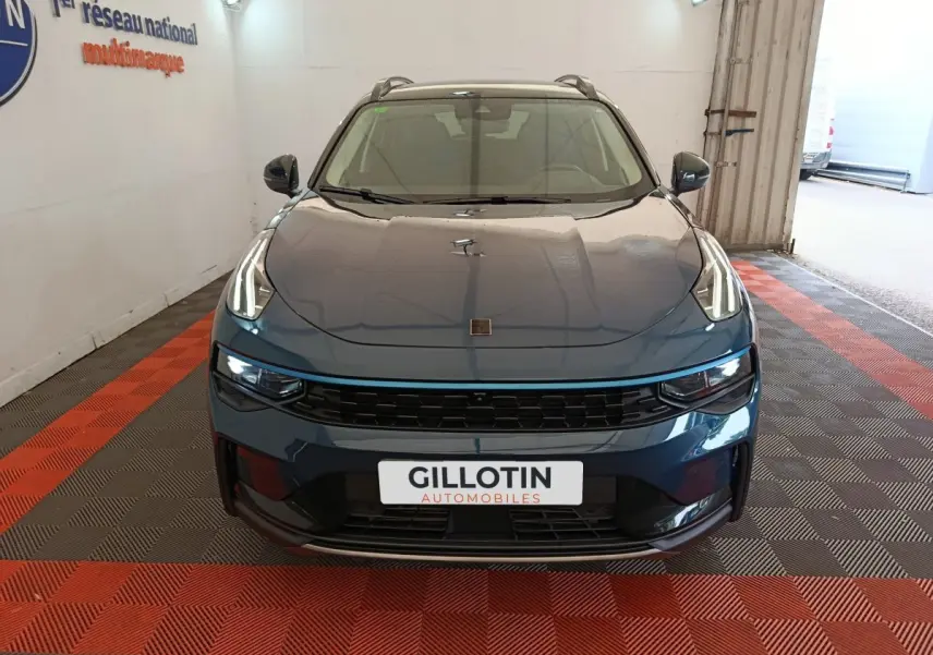 Vue frontale d'un SUV Link & Co 01 bleu avec phares LED distinctifs et calandre noire dans un garage.
