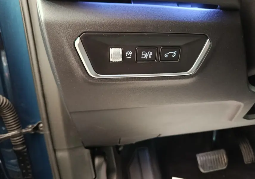 Vue rapprochée des commandes sur la partie inférieure gauche du tableau de bord d’un Link & Co 01 bleu 2022 hybride rechargeable.