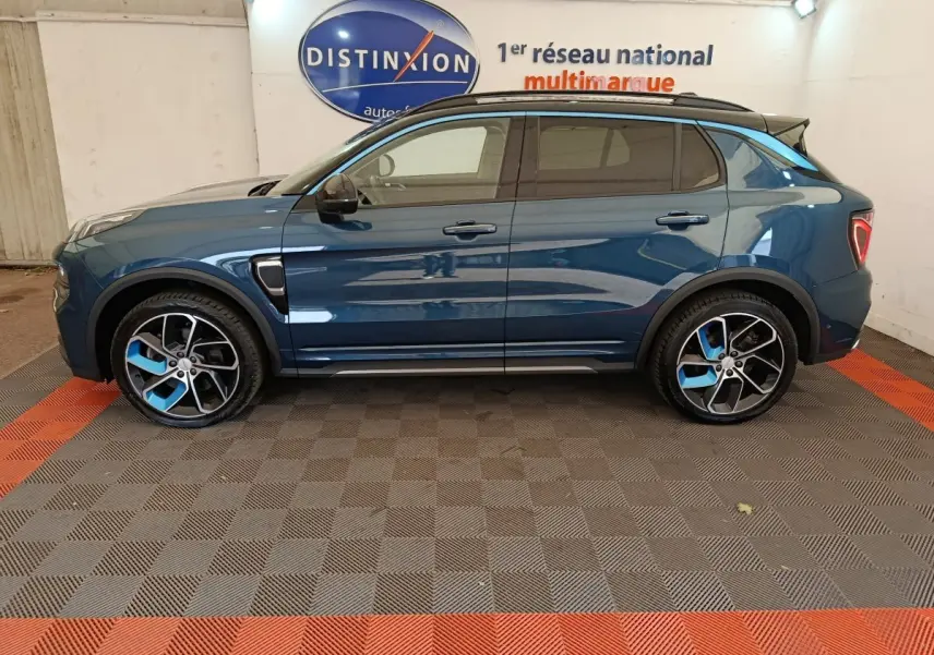 Vue de profil côté gauche du SUV LINK & CO 01 hybride rechargeable bleu avec jantes bicolores et toit noir.