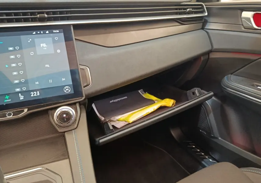 Intérieur du tableau de bord côté passager du Link & Co 01 hybride rechargeable 2022 avec boîte à gants ouverte et écran tactile central.