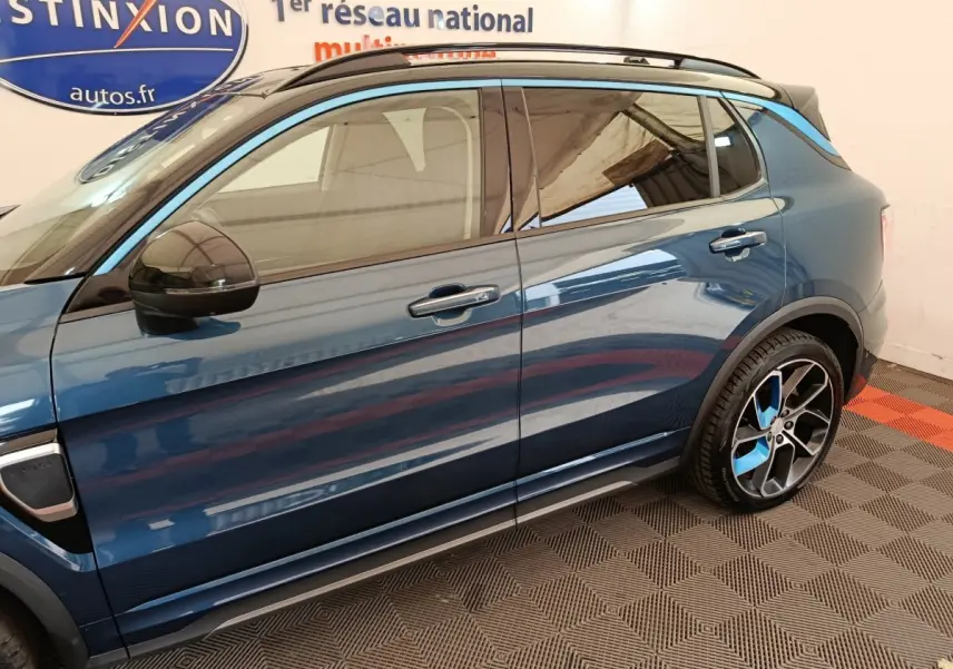 Vue latérale droite du SUV hybride rechargeable Link & Co 01 bleu avec jantes sport bicolores et rétroviseur noir.
