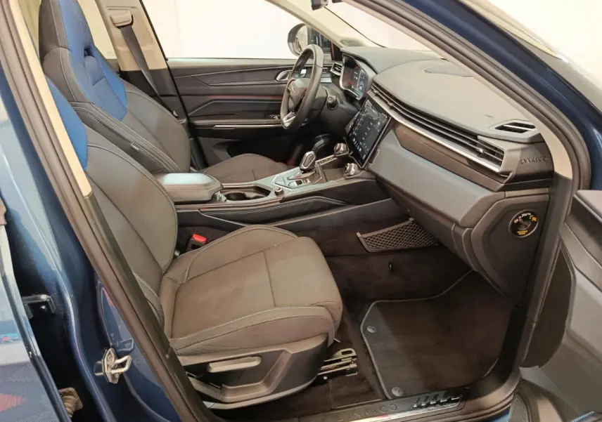 Vue intérieure côté passager avant du Lynk & Co 01 bleu, avec sièges bi-matière et tableau de bord moderne.
