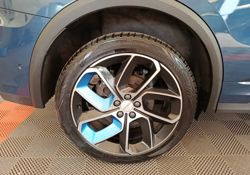 Gros plan sur la roue avant droite bleue du SUV Link & Co 01 hybride rechargeable 2022 avec jante noire et bleue.