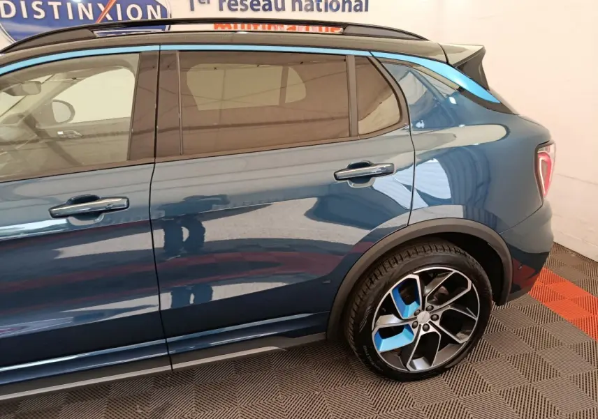 Vue latérale droite d'un SUV LINK & CO 01 hybride rechargeable bleu avec jantes noires et bleues, portes et vitres teintées.