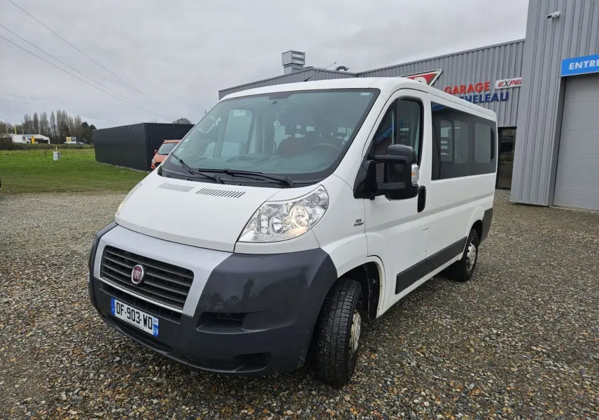 Fiat Ducato Combi blanc vu en 3/4 avant droit, fourgon 9 places avec pare-chocs noir et calandre distinctive.