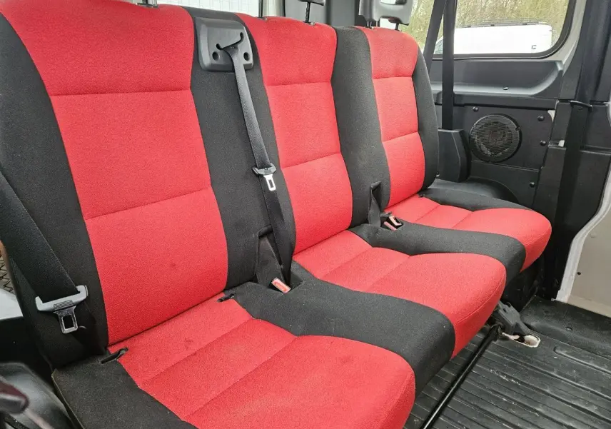 Vue intérieure des sièges arrière rouges et noirs du Fiat Ducato Combi blanc, version 9 places, avec ceintures de sécurité visibles.