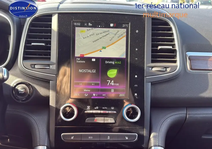 Tableau de bord noir du Renault Koleos 2017 avec écran tactile central affichant GPS et commandes climatisation.