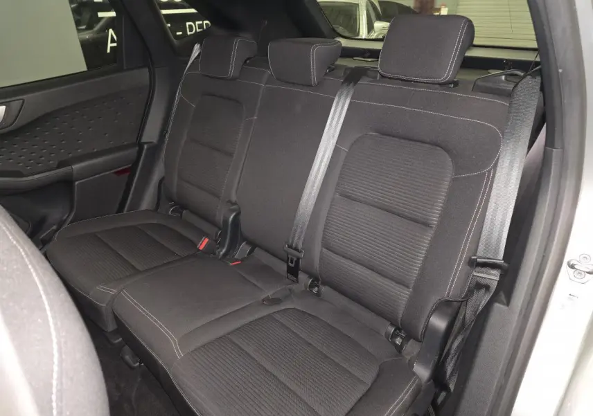 Vue intérieure des sièges arrière en tissu noir du Ford Kuga gris 2021, avec ceintures de sécurité et appuie-têtes visibles.