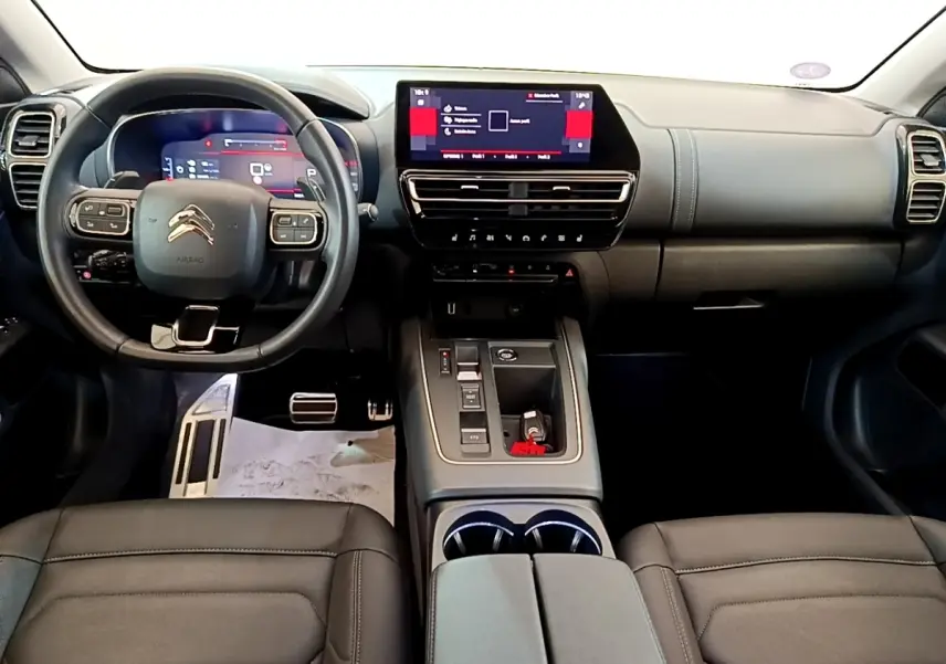 Vue intérieure avant du Citroën C5 Aircross 2023 avec tableau de bord noir et écran tactile central lumineux.