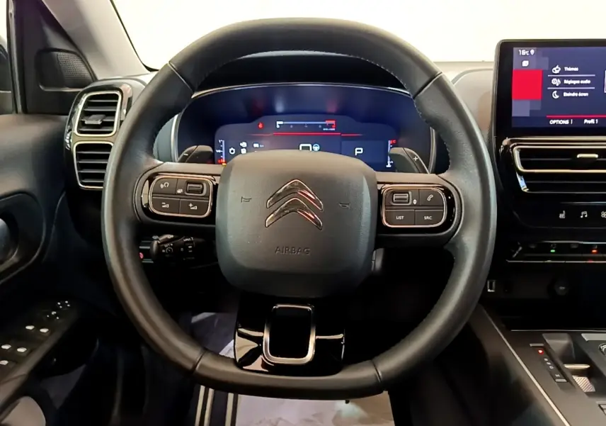 Vue centrée sur le volant cuir noir du Citroën C5 Aircross 2023 avec tableau de bord digital et écran tactile latéral.