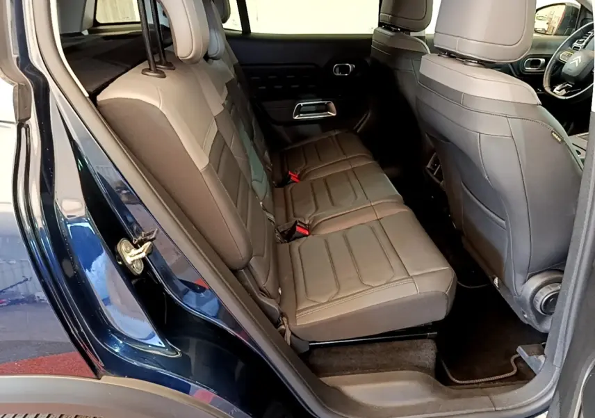 Vue intérieure côté gauche des sièges arrière en cuir marron clair du Citroën C5 Aircross 2023 avec portières ouvertes.