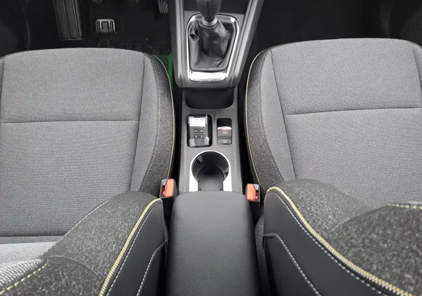 Vue plongeante sur la console centrale et les sièges avant gris foncé avec surpiqûres jaunes du Renault Symbioz 2025.