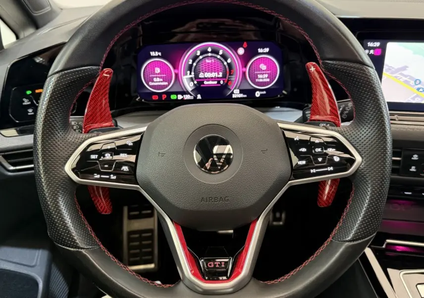 Vue rapprochée du volant perforé noir avec surpiqûres rouges et palettes rouges de la Volkswagen Golf GTI Clubsport 2022.