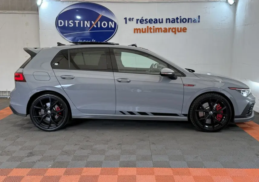 Vue latérale droite d'une Volkswagen Golf GTI Clubsport 2.0 TSI gris foncé avec jantes noires et étriers rouges.