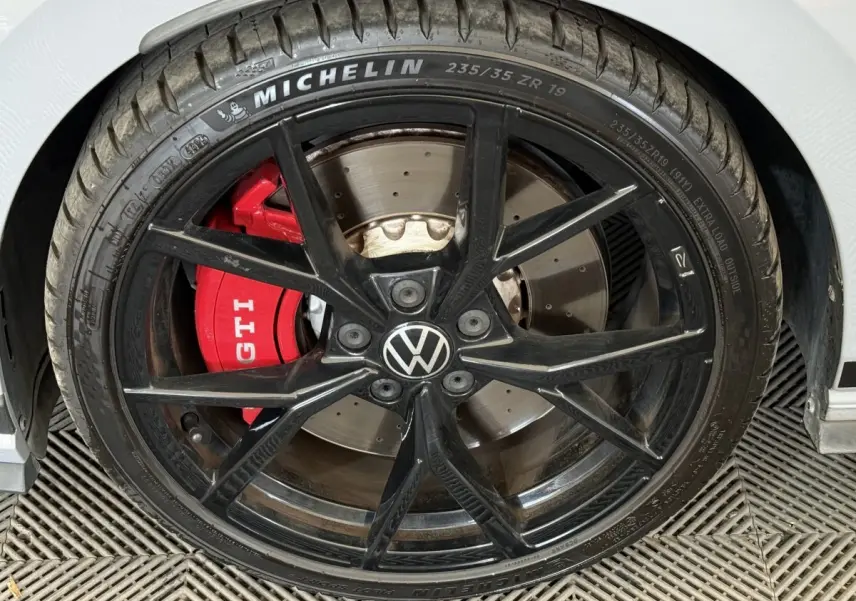 Gros plan sur la roue avant droite d'une Volkswagen Golf GTI Clubsport 2022, étrier rouge marqué GTI.
