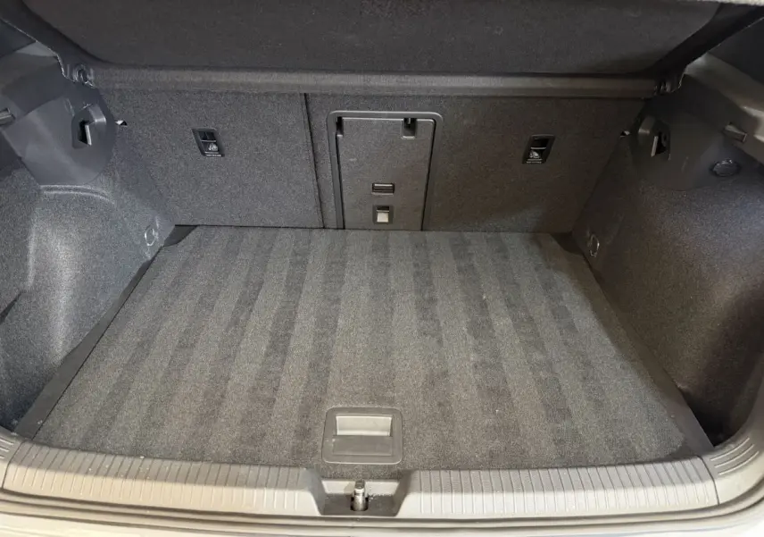 Coffre spacieux et propre de Volkswagen Golf GTI Clubsport 2022, vue intérieure depuis l'ouverture arrière, moquette grise.