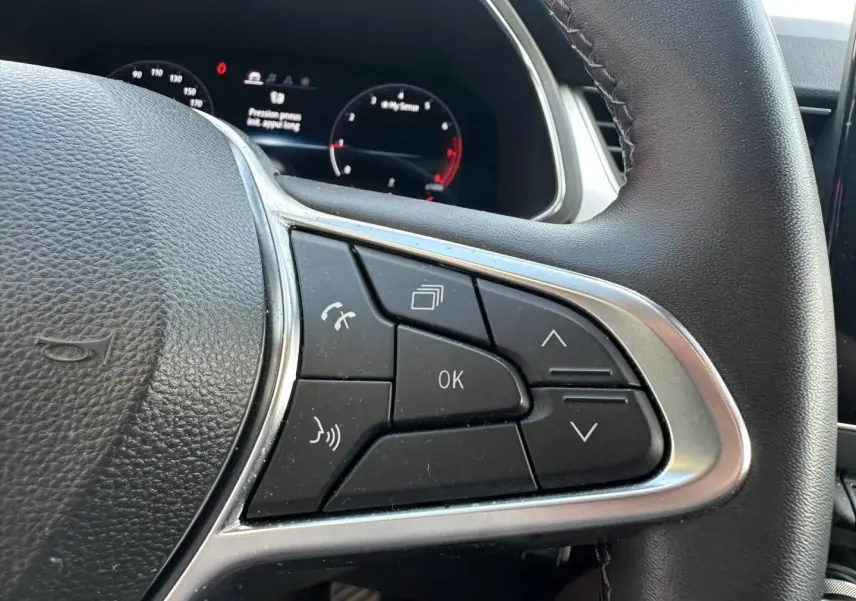 Gros plan sur les commandes multifonctions à droite du volant noir du Renault Captur 2024.