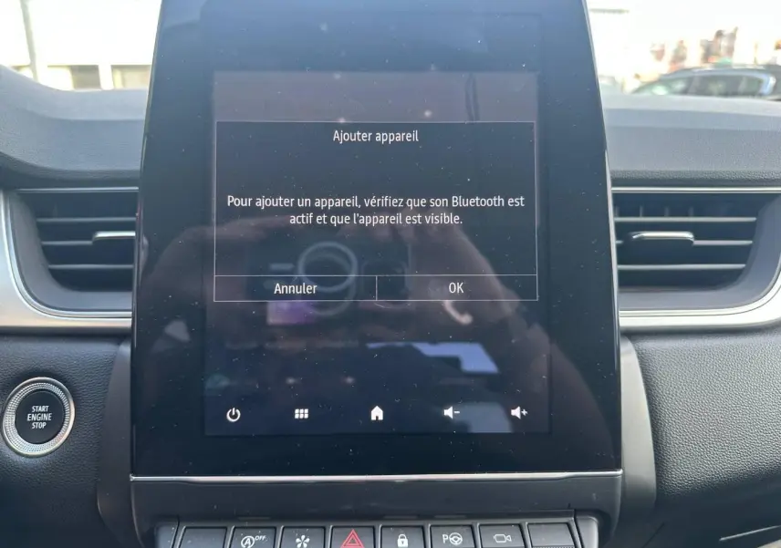 Vue rapprochée de l’écran tactile central du tableau de bord du Renault Captur 2024, avec message Bluetooth affiché.