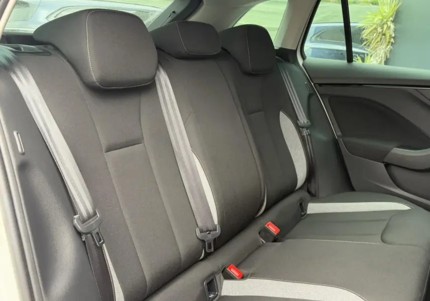 Vue intérieure arrière des sièges noirs et gris du Skoda Scala 2024, montrant les appuie-têtes et ceintures de sécurité.