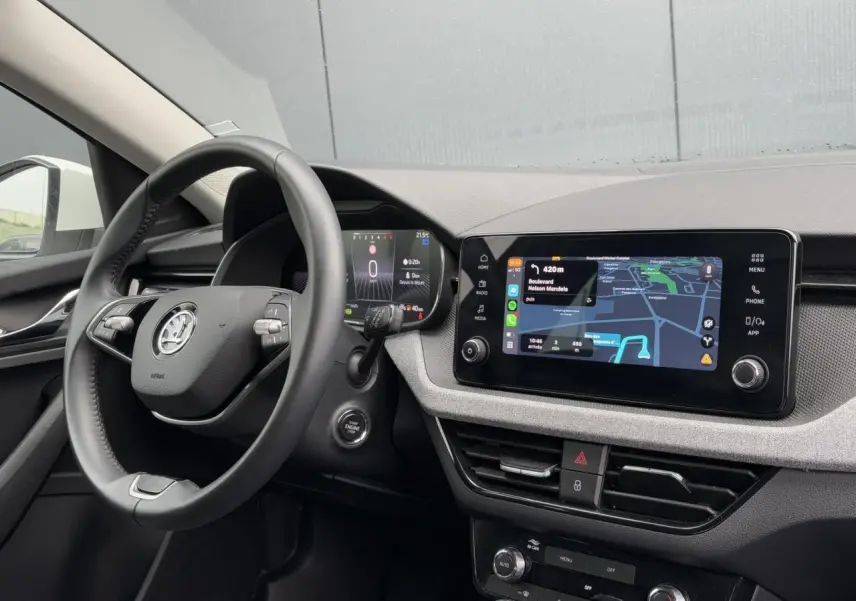 Vue intérieure côté conducteur du tableau de bord et volant cuir multifonctions d'une Skoda Scala blanc Candy 2024.