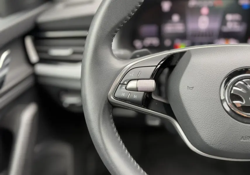 Gros plan sur le volant cuir multifonctions de la Skoda Scala 2024, mettant en valeur les commandes audio à gauche.