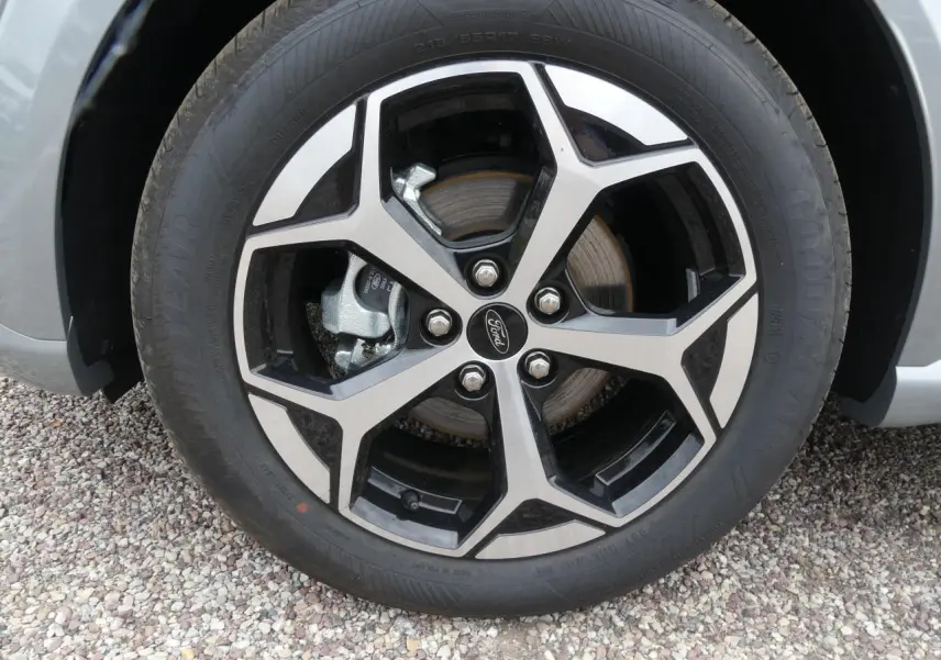 Gros plan sur la jante alliage 17 pouces bicolore du Ford Puma gris métallisé, avec logo Ford au centre.
