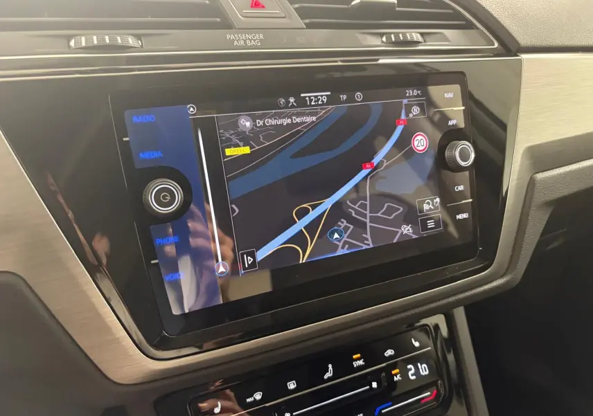 Écran tactile central du Volkswagen Touran 2025 affichant la navigation, avec commandes climatisation en dessous.