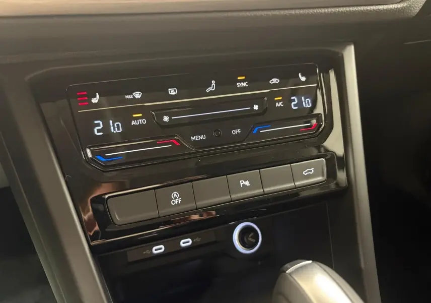 Panneau de commande de la climatisation digitale et boutons fonctionnels du Volkswagen Touran gris Dauphin, vue rapprochée intérieure.
