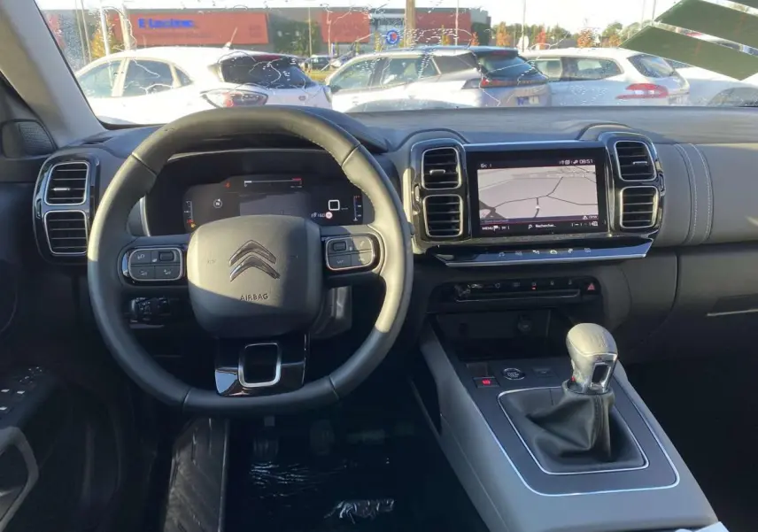 Vue intérieure du tableau de bord du Citroën C5 Aircross 2021 avec volant cuir, écran tactile et levier de vitesses manuel.
