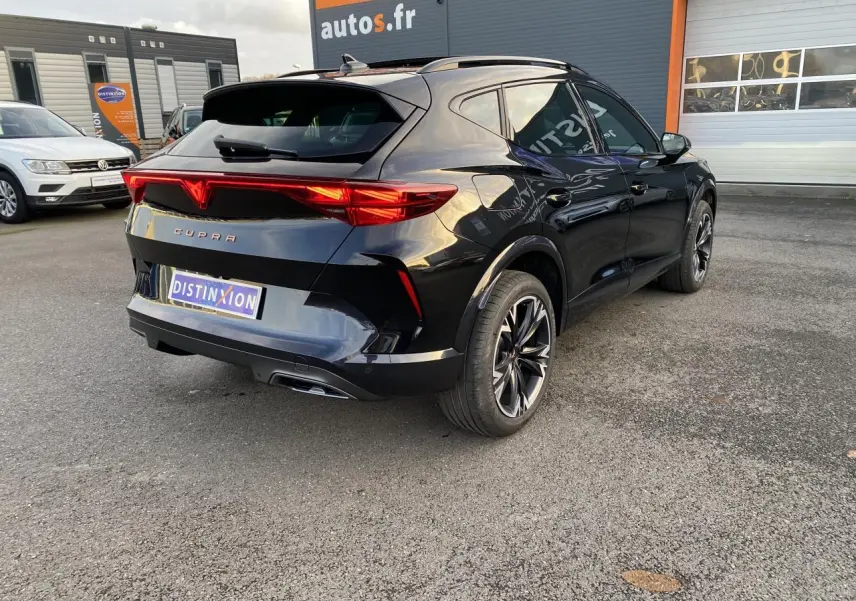 Vue 3/4 arrière droite d'un CUPRA Formentor noir Midnight avec jantes 18 pouces Sonora et feux arrière allumés.