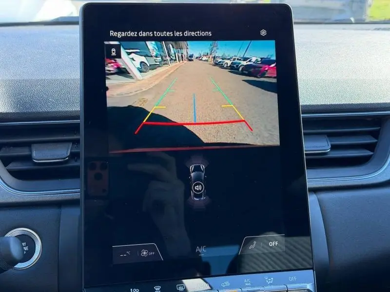 Écran central du Renault Captur 2025 montrant la caméra de recul avec lignes de guidage colorées en extérieur.