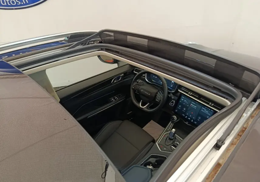 Vue plongeante sur l'intérieur noir du Lynk & Co 01 1.5 hybride rechargeable avec toit ouvrant électrique ouvert.