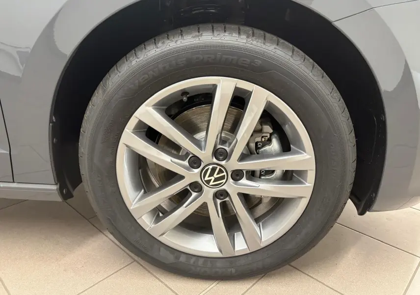 Gros plan sur la roue avant droite gris dauphin du Volkswagen Touran 2025 avec jante alliage 17 pouces et logo VW central.