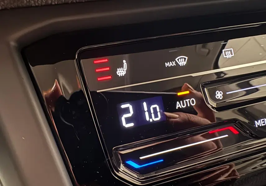 Détail du panneau de climatisation automatique à 21°C avec siège chauffant sur Volkswagen Touran gris Dauphin 2025.