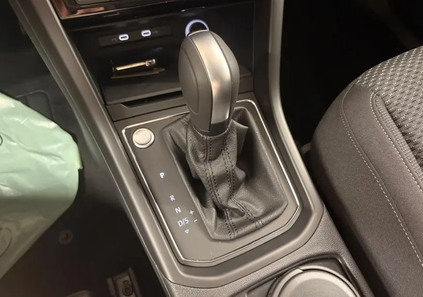 Gros plan sur la commande de boîte automatique du Volkswagen Touran 2025, intérieur noir avec levier cuir.