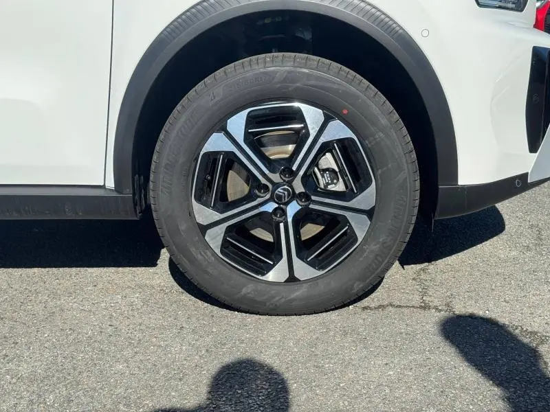 Gros plan sur la roue avant droite du Citroën C3 Aircross blanc Banquise avec jante alu bicolore noir et argent.