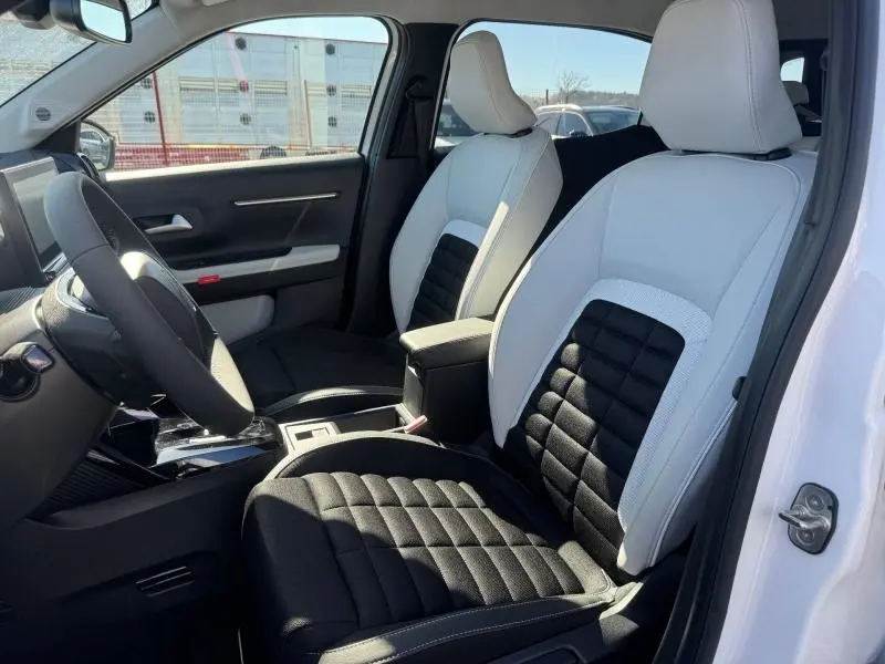 Vue intérieure côté conducteur du Citroën C3 Aircross 2026 avec sièges bicolores blanc et noir et volant multifonction.