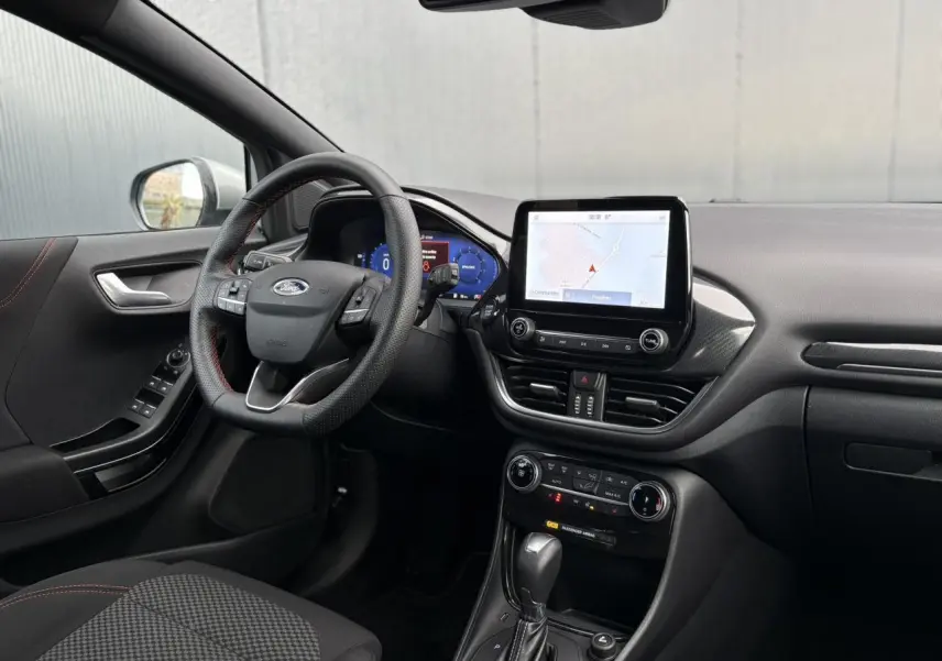 Vue intérieure côté conducteur du Ford Puma 2023, volant ST-Line, écran tactile GPS et console centrale noire.