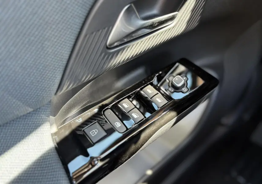 Gros plan sur les commandes de lève-vitres et rétroviseurs côté gauche d’une Citroën C5 Aircross noir Perla.